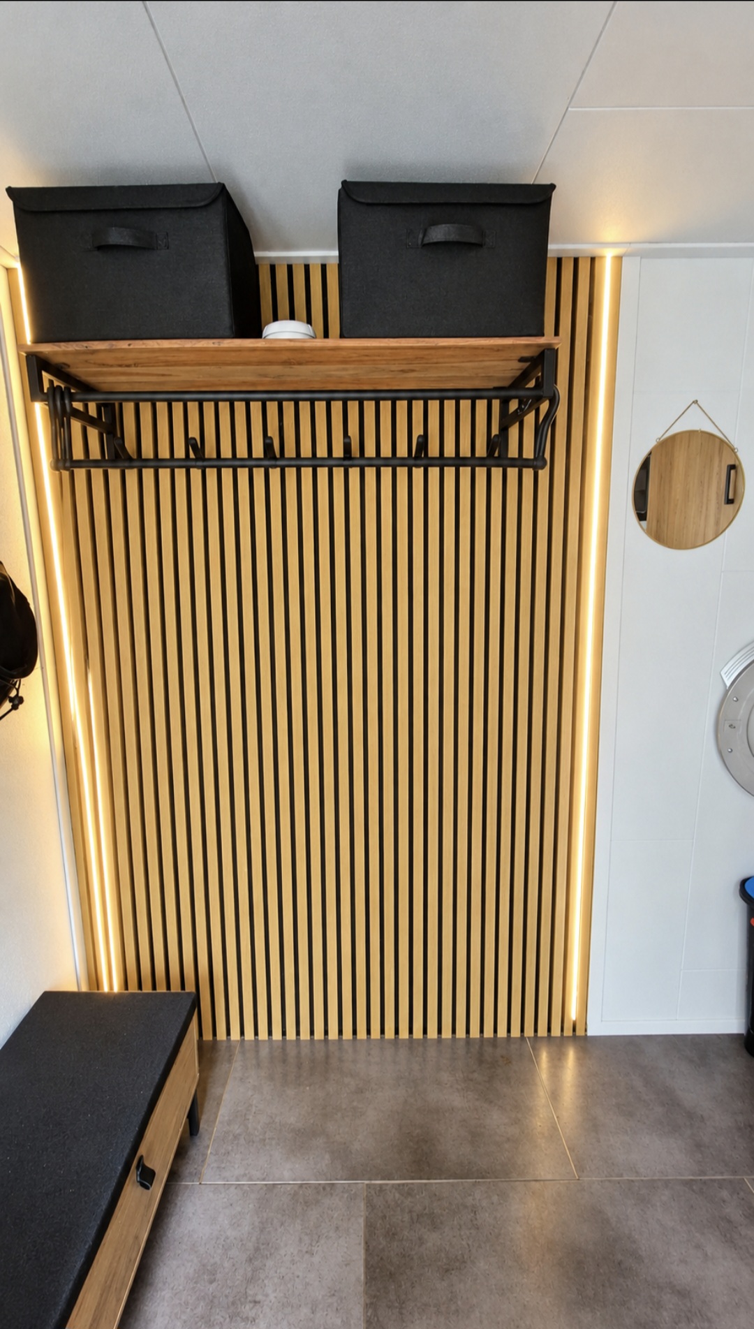 Na: houten lattenwand met kapstok, plank en LED-verlichting